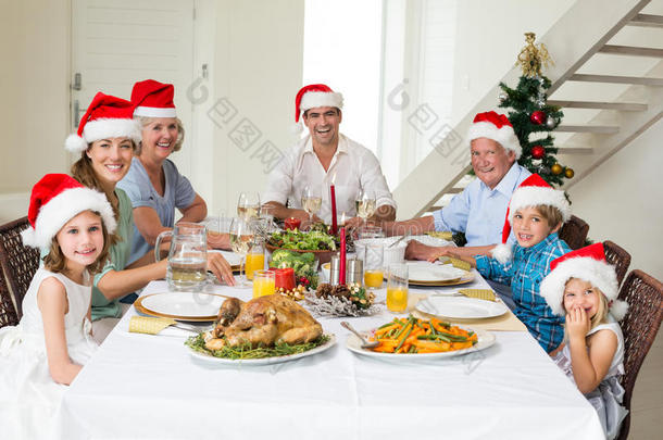 戴圣诞帽的快乐家庭吃圣诞大餐