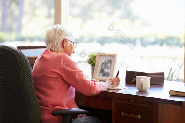 在书桌边写回忆录的老妇人