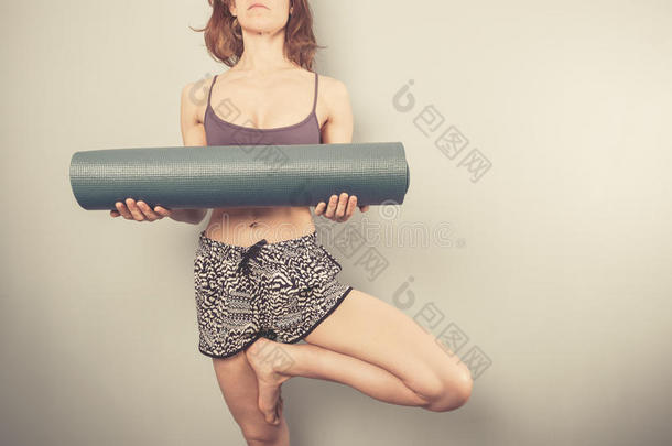 <strong>树型</strong>女人拿着瑜伽垫