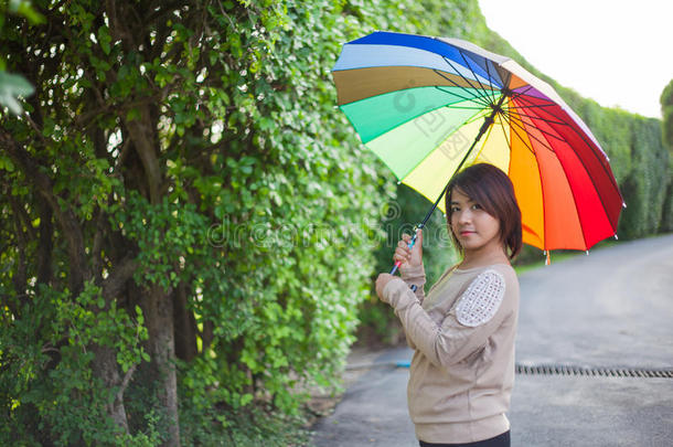 在人行道上撑伞的亚洲妇女。
