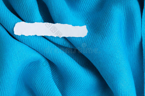 蓝布上的空白纸片波浪状褶皱织物背景