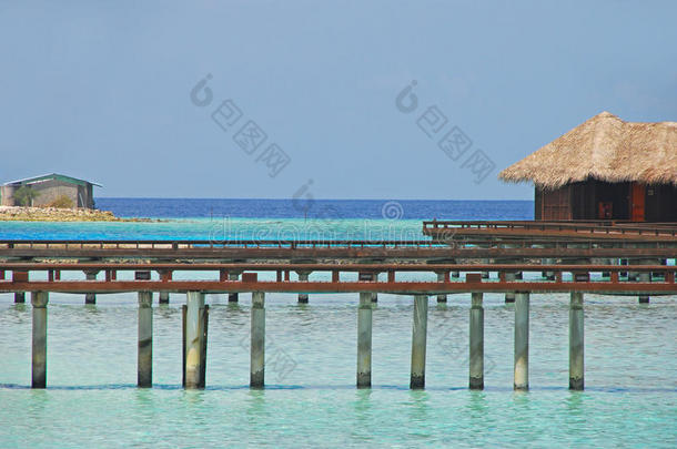 美丽的蓝天<strong>水上</strong>别墅与丑陋的小仓库通过木制走道桥连接在<strong>马尔代夫</strong>的一个度假岛，<strong>马尔代夫</strong>