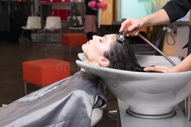 美丽的黑发女人悠闲的洗发水站专业洗发水