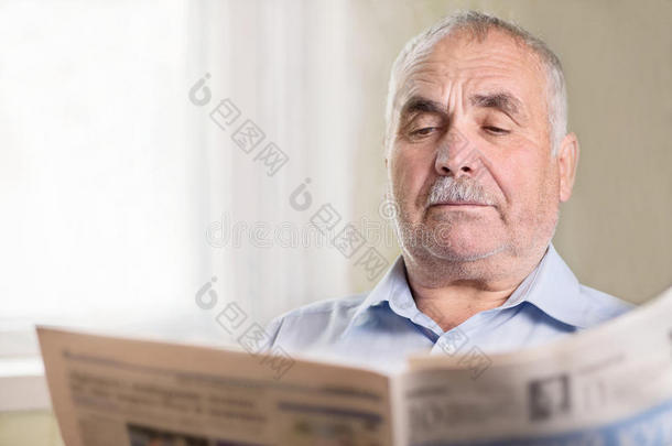 高级白人在家看报纸