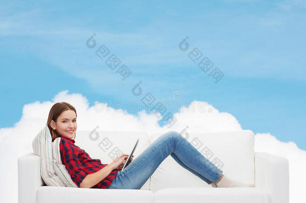 坐在沙发上玩平板电脑的少女