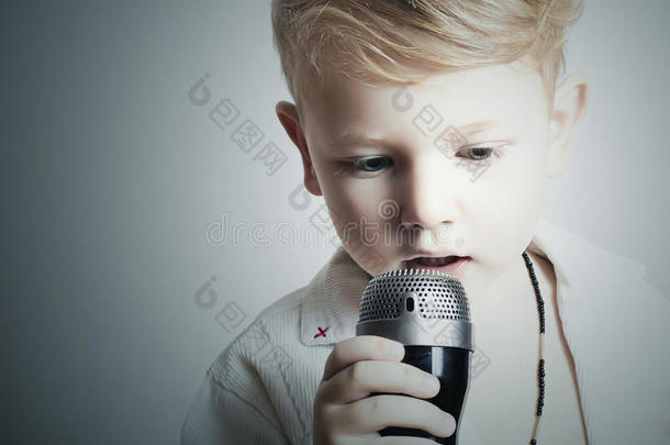 孩子。小男孩在唱歌卡拉OK。麦克风。歌手