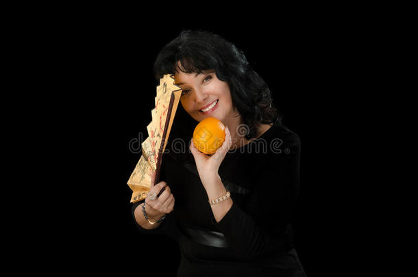 微笑的女演员拿着<strong>折扇</strong>和橘子