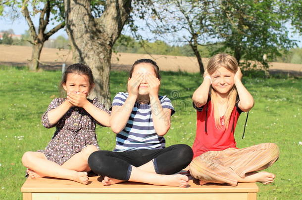 三个微笑的女孩坐在桌子上