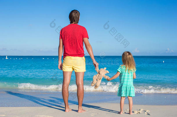 爸爸带着小宝宝在异国情调的海滩上拿着一个<strong>毛绒玩具</strong>