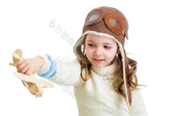 微笑的孩子穿上飞行员的衣服，玩着木制的<strong>飞机玩具</strong>