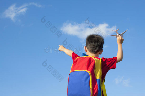 小男孩拿着飞机玩具和指点