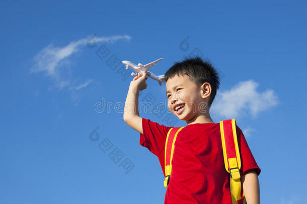 背着背包拿着飞机玩具的小男孩