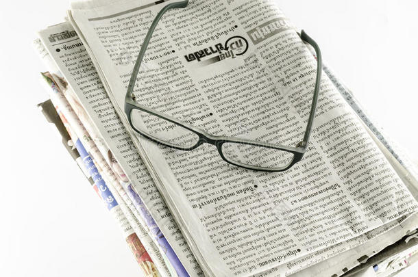 一摞带眼镜的报纸