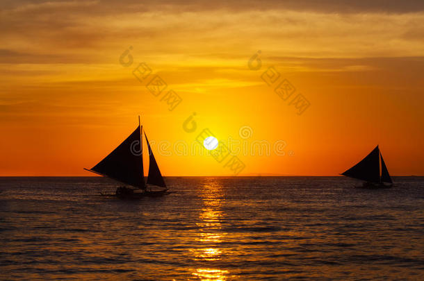 热带海上日落时的帆船。剪影照片。