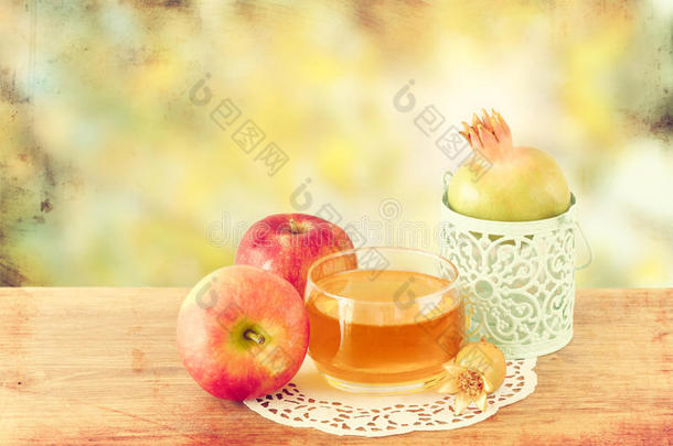rosh hashanah概念-木制桌子上的苹果蜂蜜和石榴