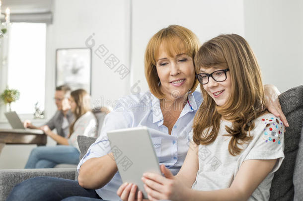 亲情母女用平板电脑，家人坐在家里