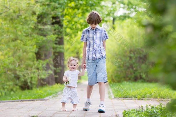 小学生和他的妹妹在公园散步