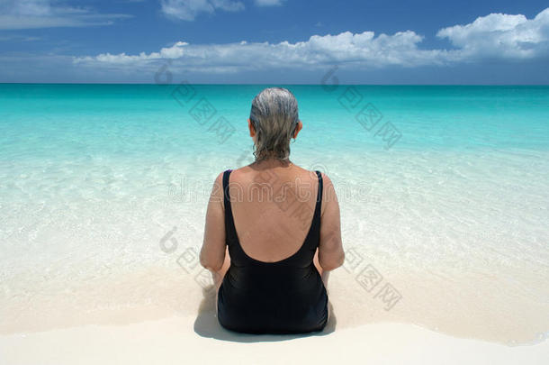 老人从加勒比海宁静的海滩眺望大海