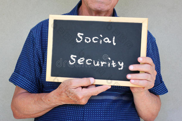 一位老人手里拿着写着“<strong>社会保障</strong>”字样的黑板。