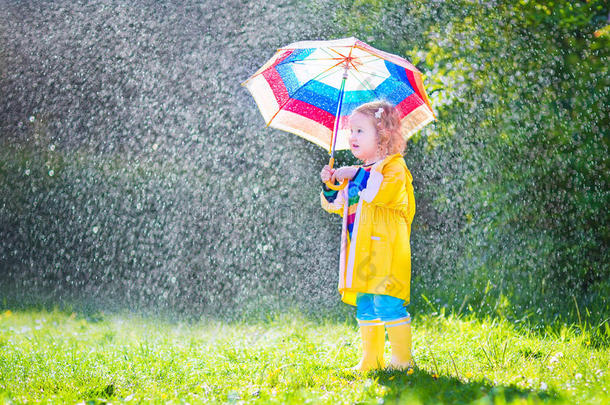 有趣的小孩在雨中打伞