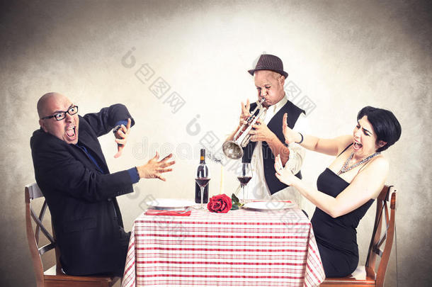 一对愤怒的夫妇在吃饭时被小号音乐家打扰了