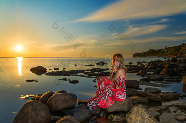 一个穿着盛装的女人在海上日落