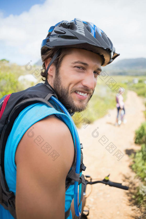 合身情侣骑自行车在山路上男人微笑着对着镜