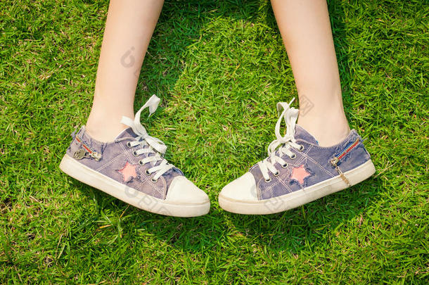 草地上女孩腿上的青春运动鞋