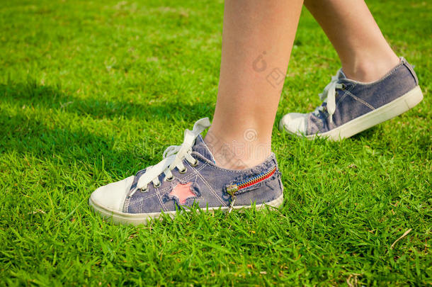草地上女孩腿上的青春运动鞋