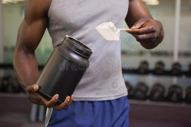 健身者在健身房拿着一勺蛋白质混合物