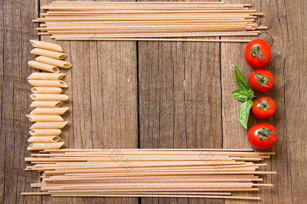 木制背景的意大利面、西红柿和罗勒