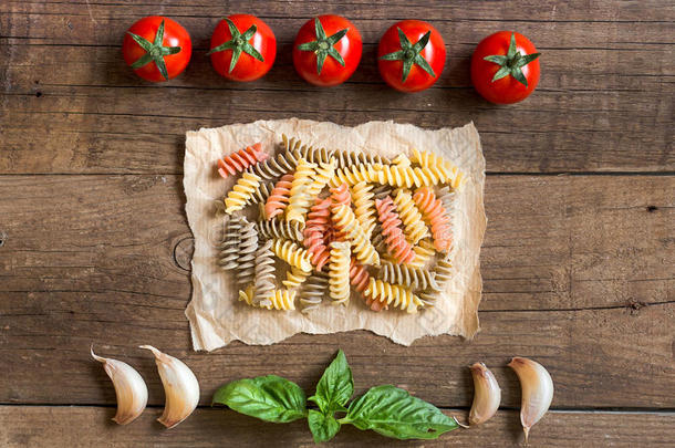 意大利面，西红柿，大蒜和罗勒在木质背景上