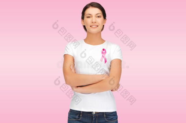 微笑的女人带着粉红色的癌症意识丝带