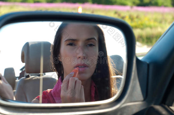 在汽车镜上涂口红的女人