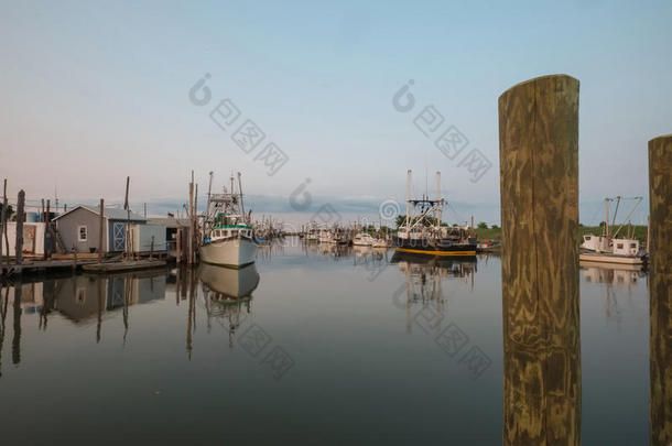 牡蛎和拖网渔船在日落时靠岸