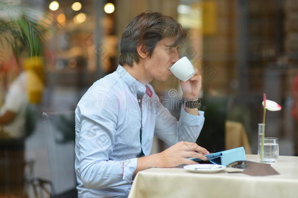 年轻时尚男士/时尚达人在城市咖啡厅喝浓缩咖啡