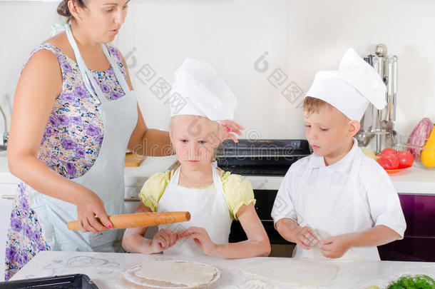 母亲教两个孩子烤面包