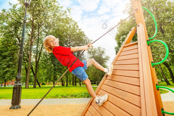 <strong>积极向上的</strong>男孩爬上了木制建筑