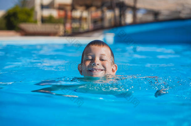 孩子在游泳池里游泳和玩耍。夏季