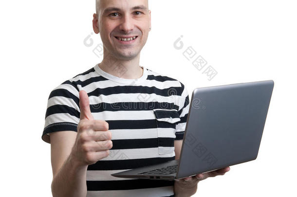 快乐的年轻人穿着t恤在笔记本电脑上工作