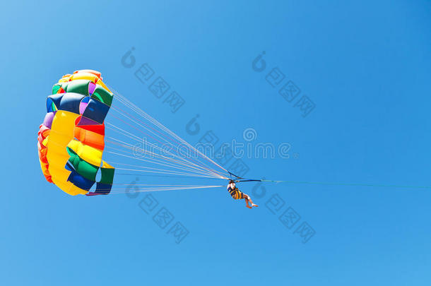 在蓝天下，一个女人在降落伞上滑翔