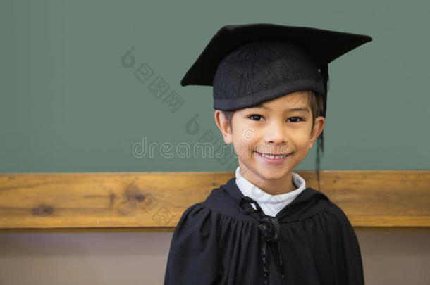 教室里穿着毕业袍的可爱小学生对着镜头微笑