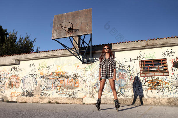 <strong>涂鸦</strong>背景上穿着溜冰鞋和<strong>篮球</strong>的女孩