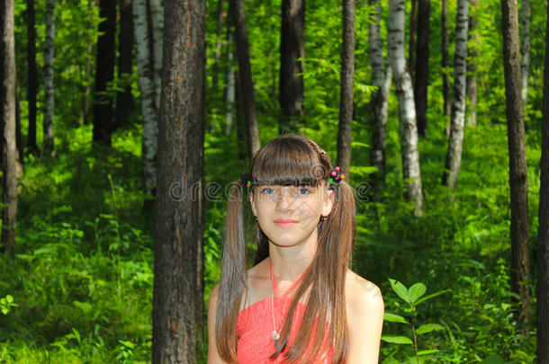 穿红裙子的女孩在树林里散步