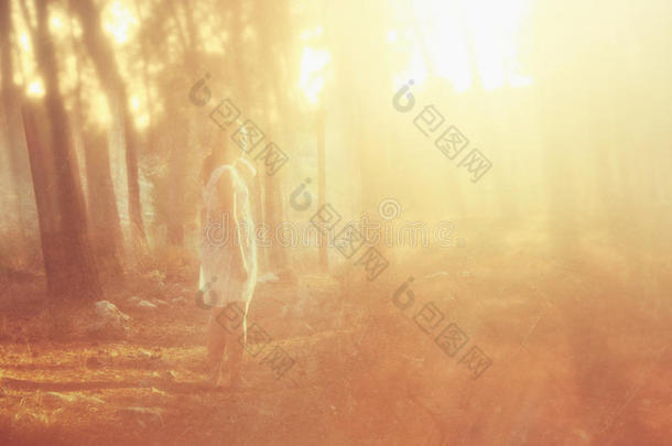 年轻女子站在森林里的超现实照片。图像有纹理和色调。梦幻般的概念。