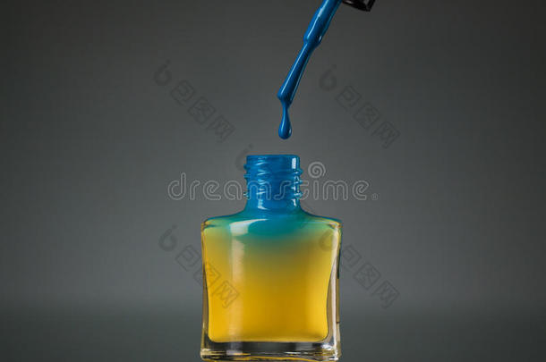 流动的蓝色指甲油在黄色的瓶子里隔离<strong>开来</strong>