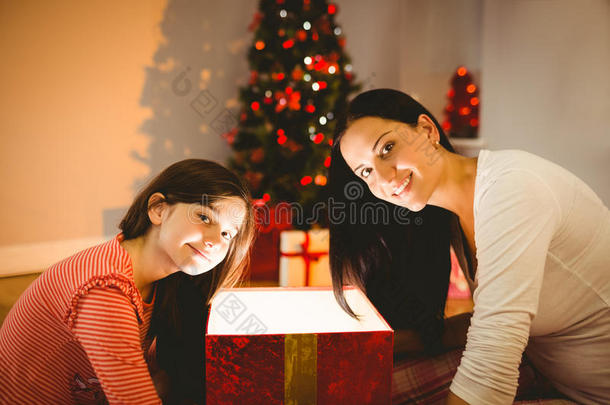喜庆的母女俩打开一份闪闪发光的圣诞礼物