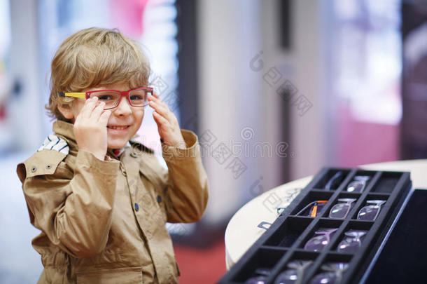 一个可爱的小男孩在眼镜店挑选他的新眼镜