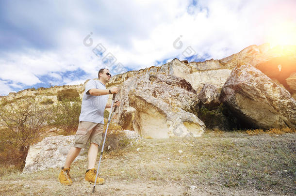 一个成年男子正在用<strong>登山杖</strong>徒步旅行