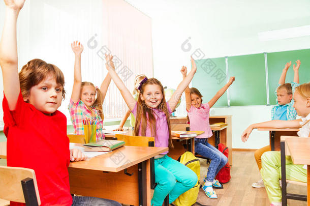 男孩和女孩在课堂上举手